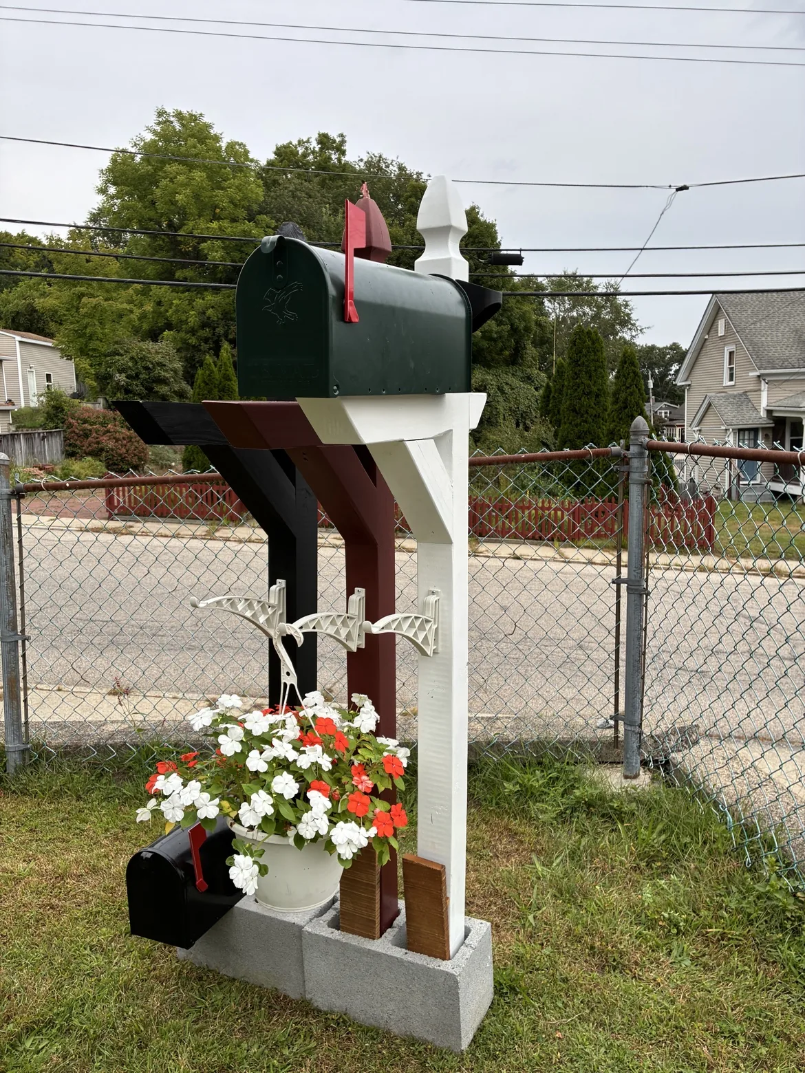 Mailbox mounted on post with solar lights and flower basket